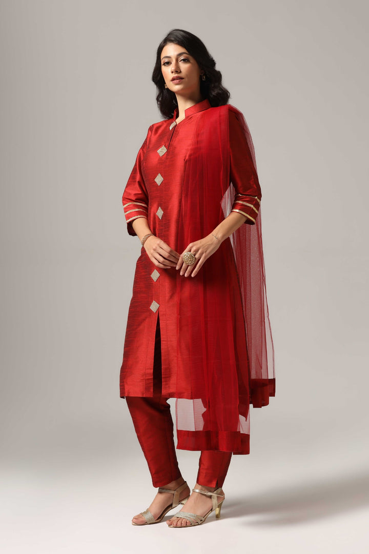 Maroon raw silk kurti paired with pants and a matching net dupatta