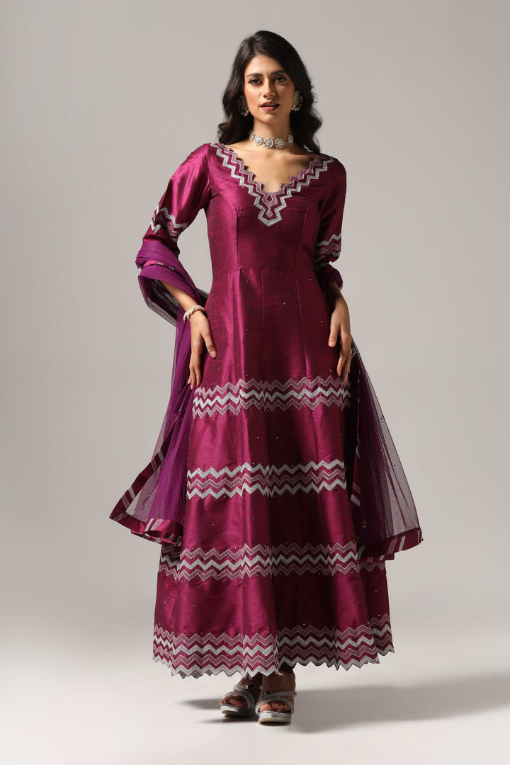 Purple raw silk machine embroidered anarkali paired with churidar and a matching net dupatta.