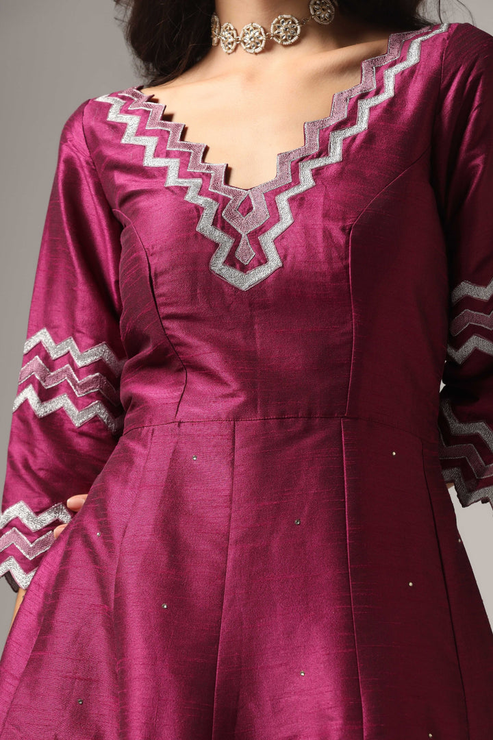 Purple raw silk machine embroidered anarkali paired with churidar and a matching net dupatta.