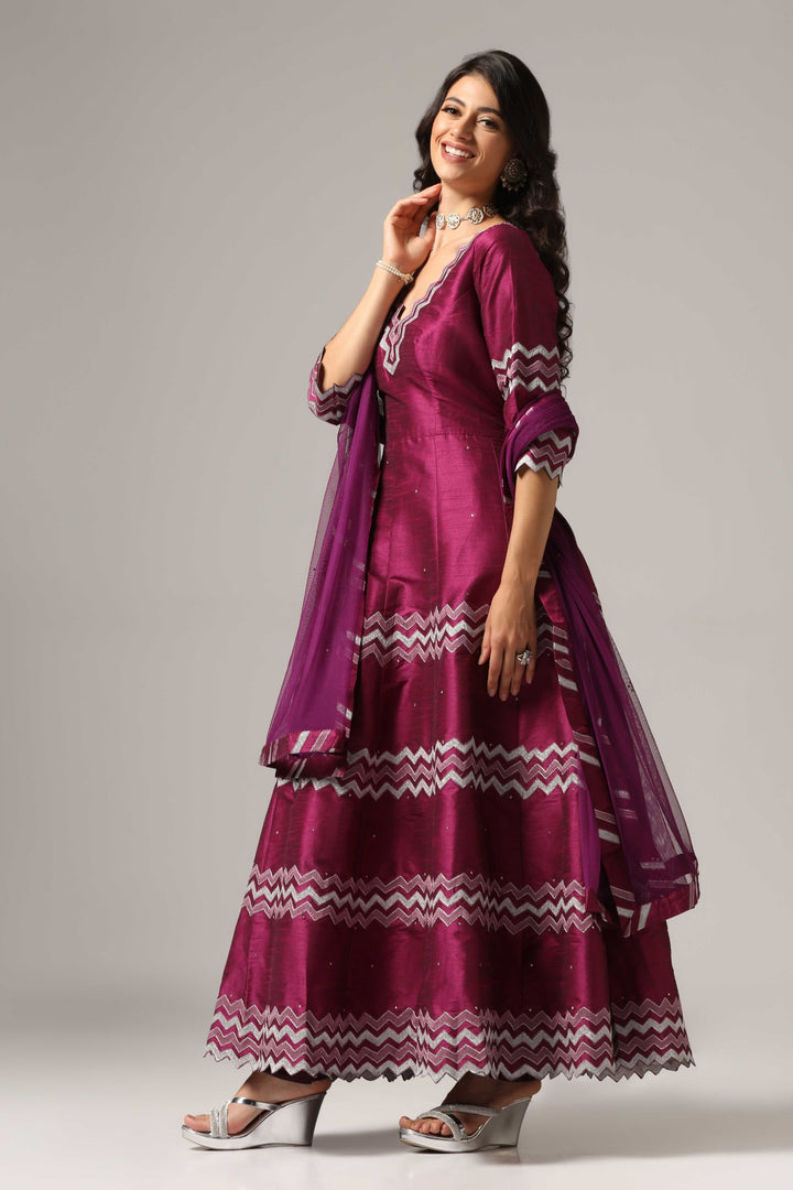 Purple raw silk machine embroidered anarkali paired with churidar and a matching net dupatta.