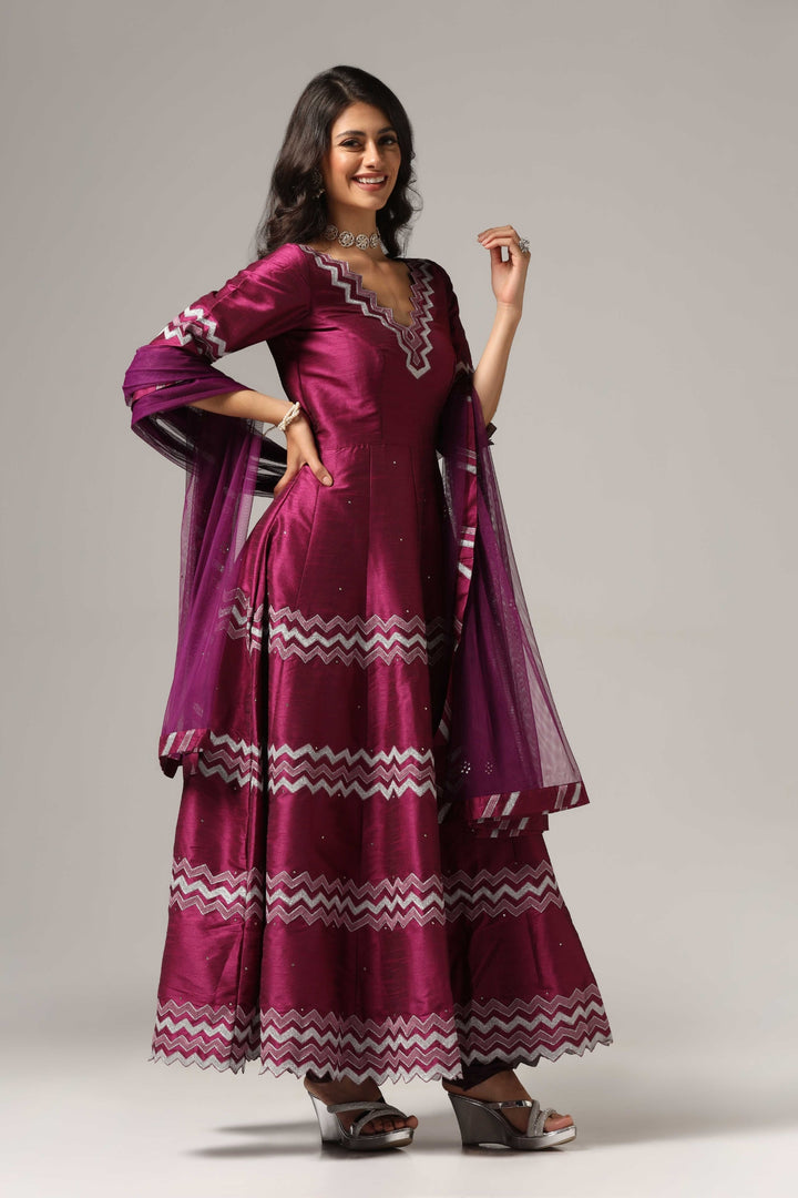 Purple raw silk machine embroidered anarkali paired with churidar and a matching net dupatta.