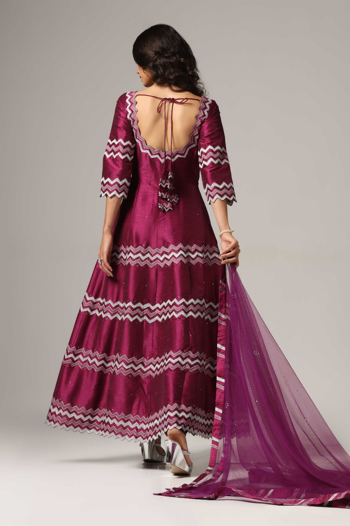 Purple raw silk machine embroidered anarkali paired with churidar and a matching net dupatta.