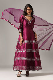 Purple raw silk machine embroidered anarkali paired with churidar and a matching net dupatta.