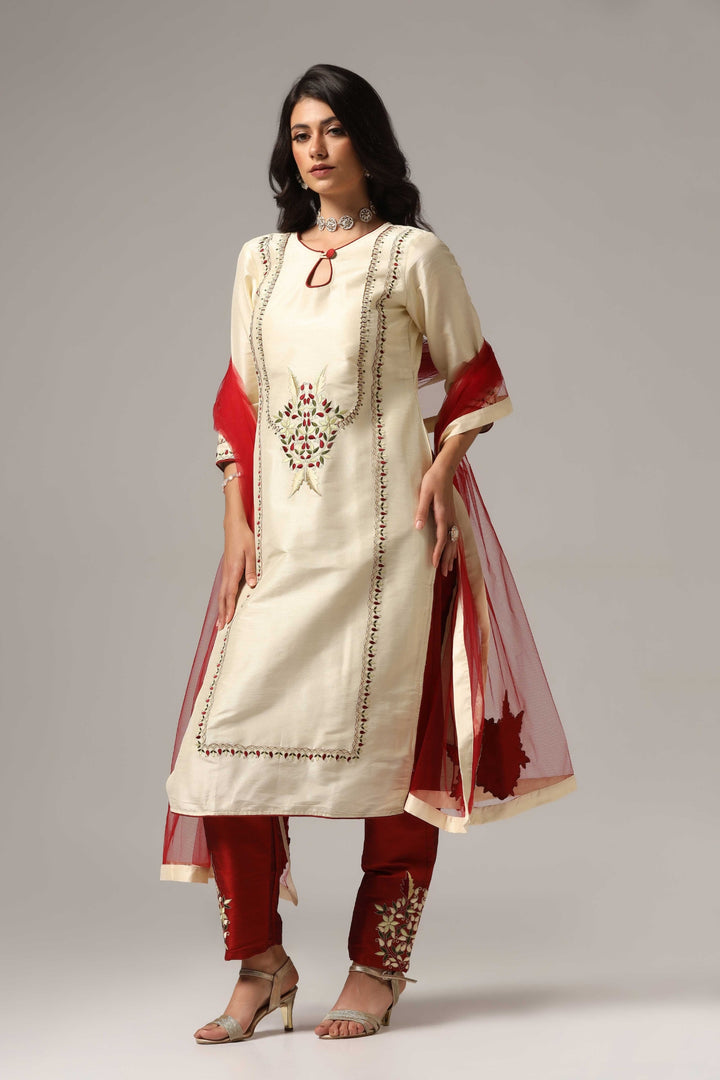 Creme raw silk embroidered kurti paired with pants and a net maching dupatta.