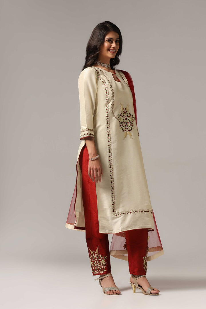 Creme raw silk embroidered kurti paired with pants and a net maching dupatta.