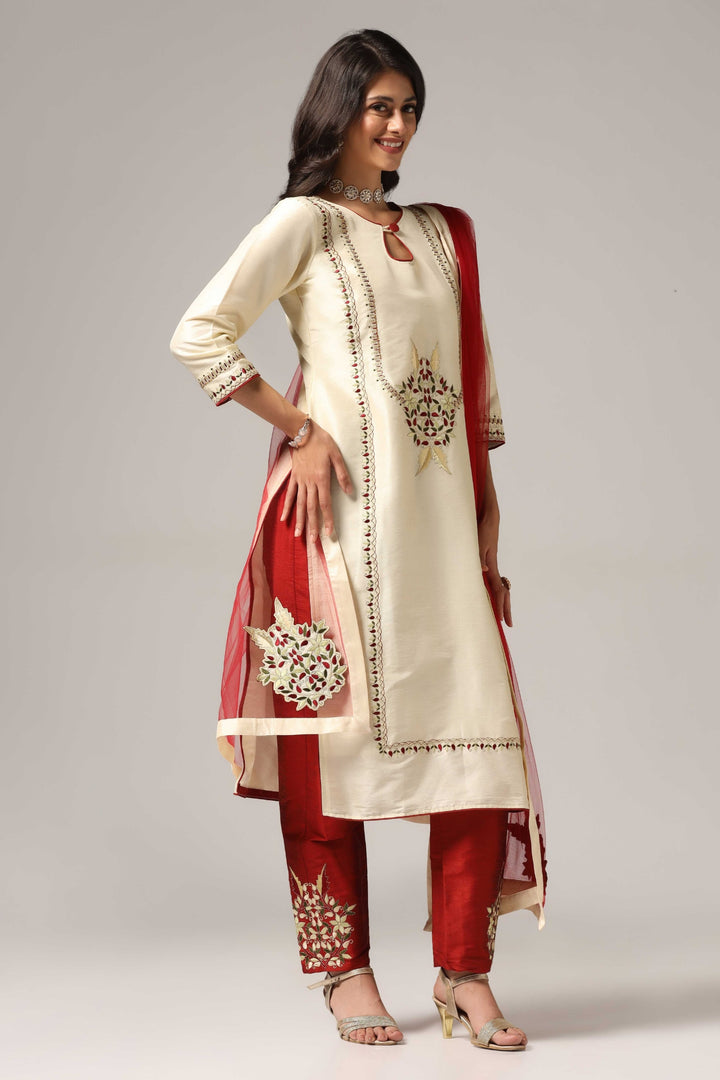 Creme raw silk embroidered kurti paired with pants and a net maching dupatta.