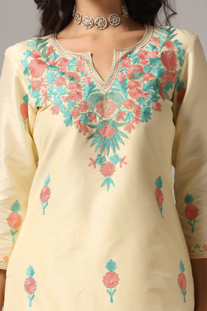 Creme raw silk ari embroidered kurti paired with pants and a net maching dupatta