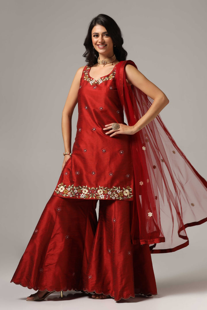 Maroon raw silk sharara set adorned with multi-color resham embroidery, paired with a match net dupatta