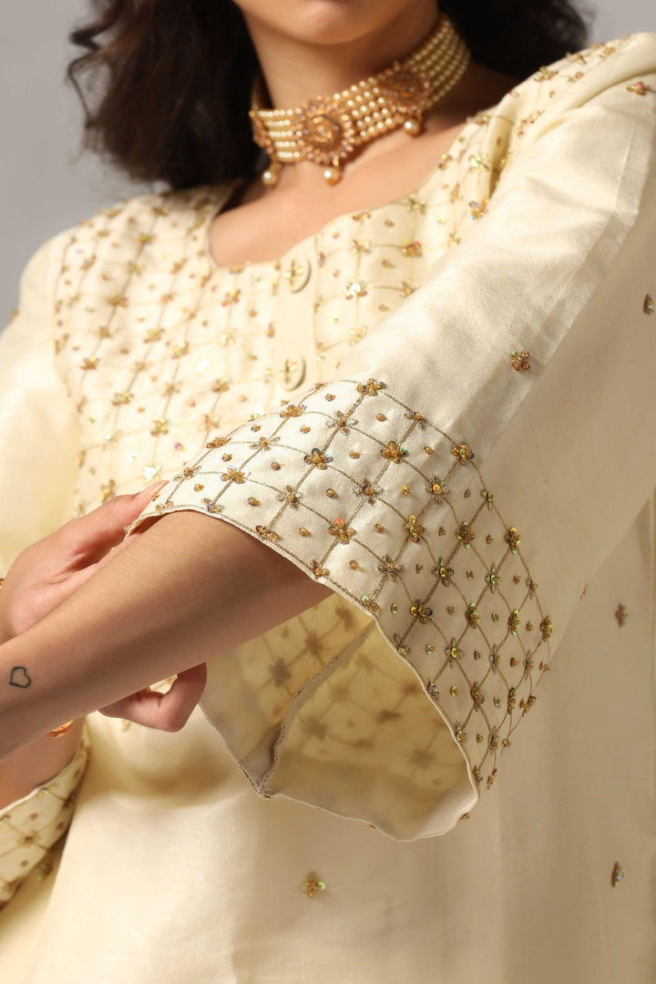 Creme raw silk gold zari embroidered & hand crafted with sequence kurti paired with pants and a net dupatta